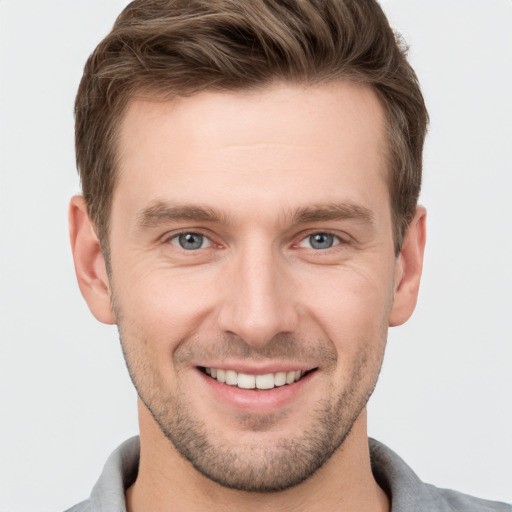 Joyful white young-adult male with short  brown hair and grey eyes