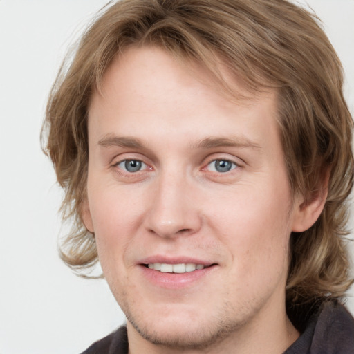 Joyful white young-adult male with medium  brown hair and grey eyes