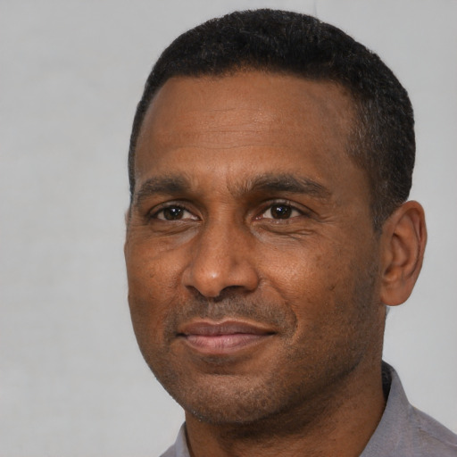 Joyful black adult male with short  black hair and brown eyes
