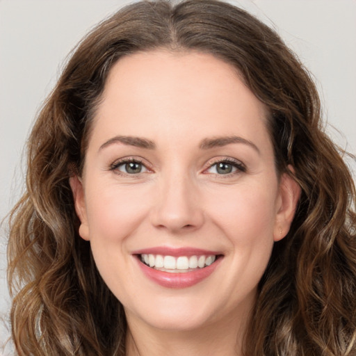 Joyful white young-adult female with long  brown hair and green eyes