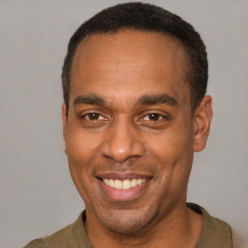 Joyful latino adult male with short  brown hair and brown eyes
