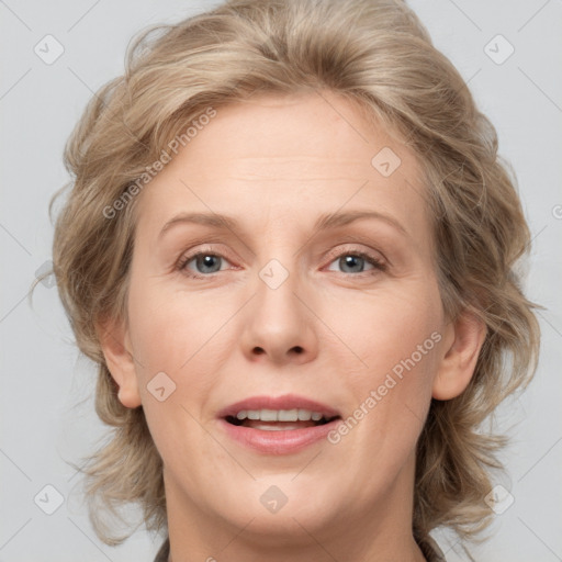 Joyful white adult female with medium  brown hair and blue eyes