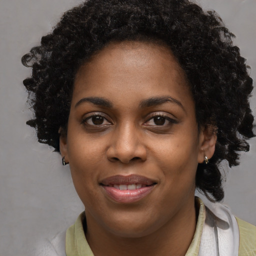 Joyful black young-adult female with short  brown hair and brown eyes