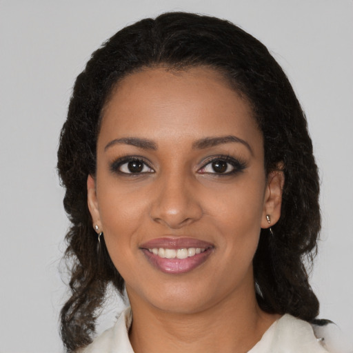 Joyful black young-adult female with medium  brown hair and brown eyes