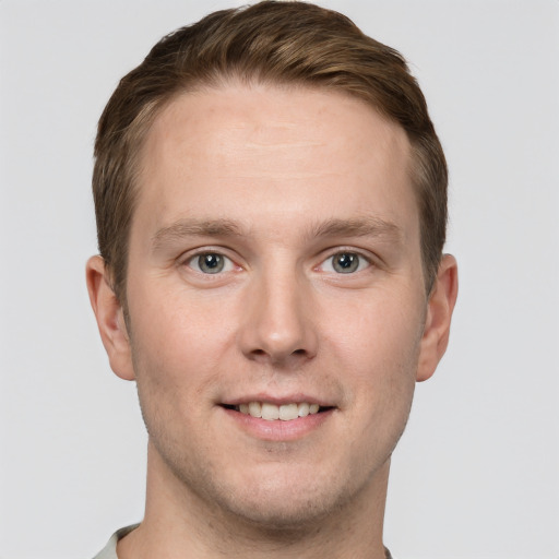 Joyful white young-adult male with short  brown hair and grey eyes