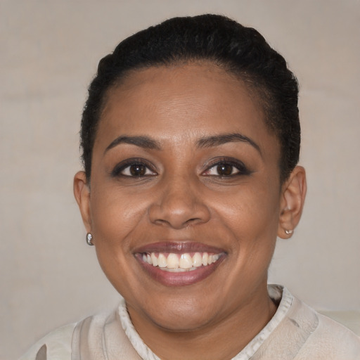 Joyful black young-adult female with short  black hair and brown eyes
