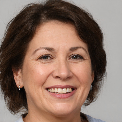 Joyful white adult female with medium  brown hair and brown eyes