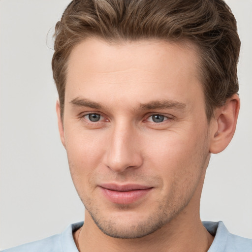 Joyful white young-adult male with short  brown hair and grey eyes