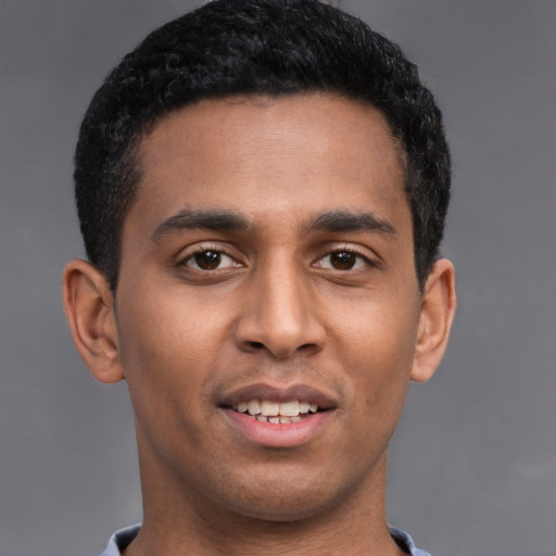 Joyful latino young-adult male with short  brown hair and brown eyes