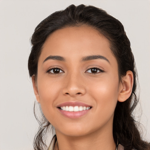 Joyful latino young-adult female with long  brown hair and brown eyes