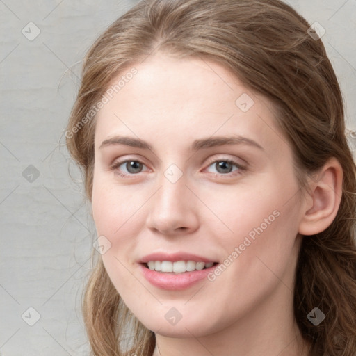 Joyful white young-adult female with long  brown hair and blue eyes