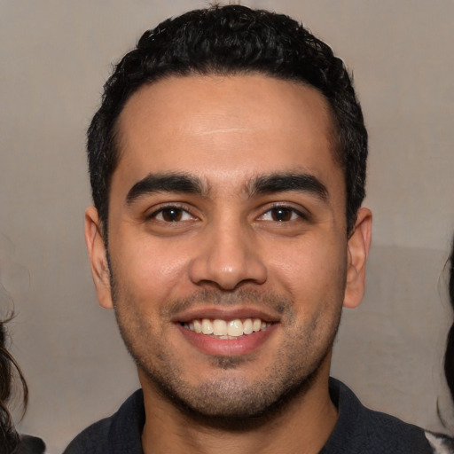 Joyful white young-adult male with short  black hair and brown eyes