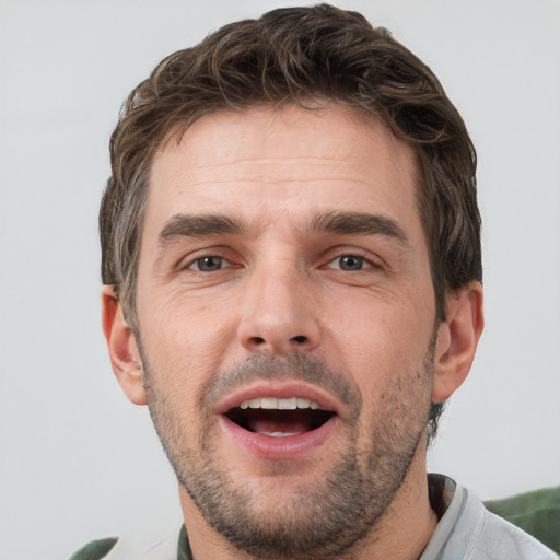 Joyful white adult male with short  brown hair and grey eyes