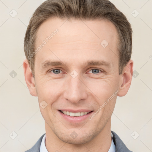 Joyful white adult male with short  brown hair and grey eyes