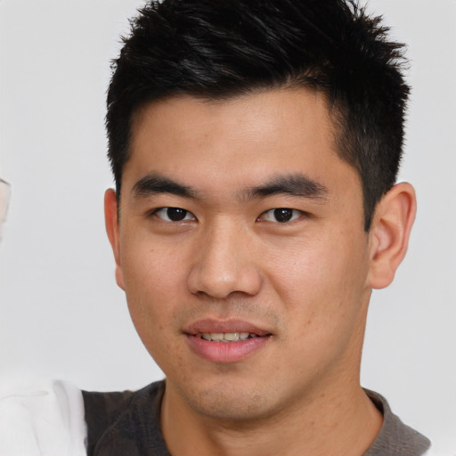 Joyful asian young-adult male with short  brown hair and brown eyes