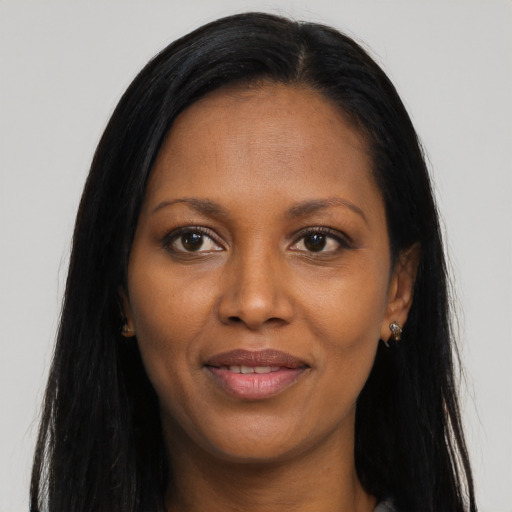 Joyful black young-adult female with long  brown hair and brown eyes