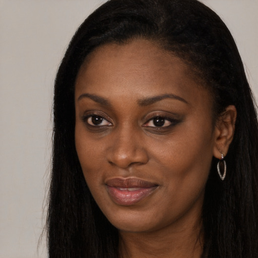 Joyful black young-adult female with long  brown hair and brown eyes