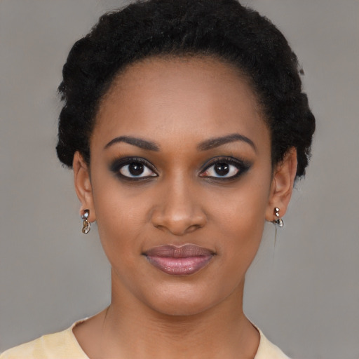 Joyful black young-adult female with short  black hair and brown eyes