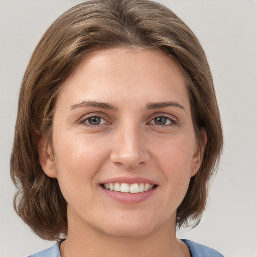 Joyful white young-adult female with medium  brown hair and grey eyes