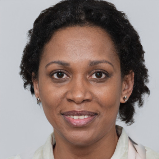 Joyful black adult female with short  brown hair and brown eyes