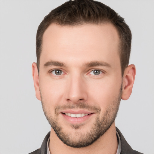 Joyful white young-adult male with short  brown hair and grey eyes