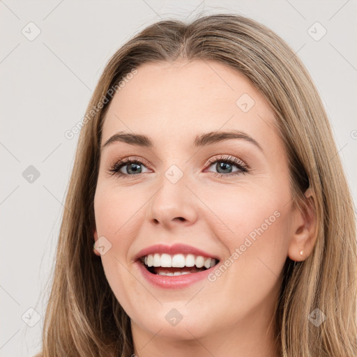 Joyful white young-adult female with long  brown hair and grey eyes