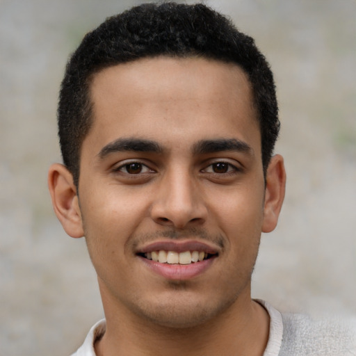 Joyful latino young-adult male with short  brown hair and brown eyes