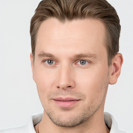 Joyful white young-adult male with short  brown hair and grey eyes