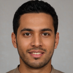 Joyful latino young-adult male with short  black hair and brown eyes