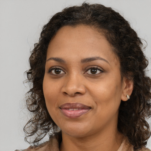 Joyful black young-adult female with medium  brown hair and brown eyes