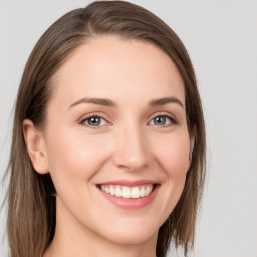 Joyful white young-adult female with long  brown hair and grey eyes