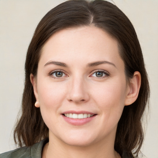 Joyful white young-adult female with medium  brown hair and grey eyes