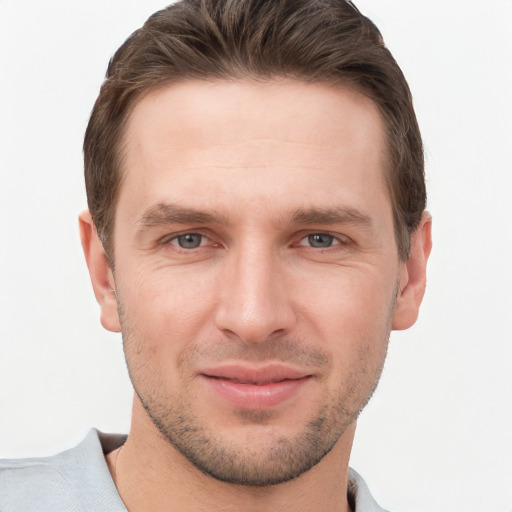 Joyful white young-adult male with short  brown hair and grey eyes