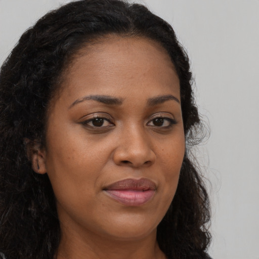 Joyful black young-adult female with long  brown hair and brown eyes