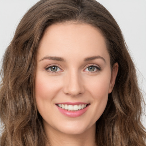 Joyful white young-adult female with long  brown hair and green eyes