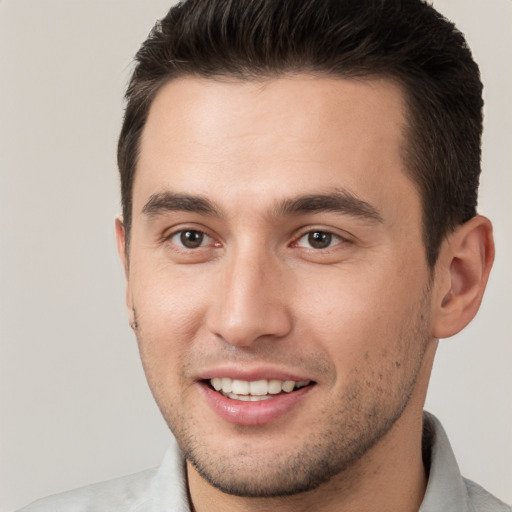 Joyful white young-adult male with short  brown hair and brown eyes