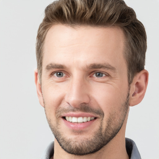 Joyful white young-adult male with short  brown hair and grey eyes