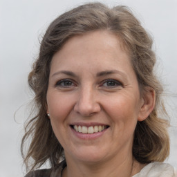 Joyful white adult female with medium  brown hair and grey eyes