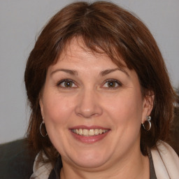 Joyful white adult female with medium  brown hair and brown eyes