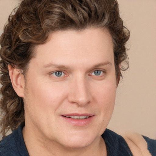 Joyful white young-adult male with medium  brown hair and blue eyes