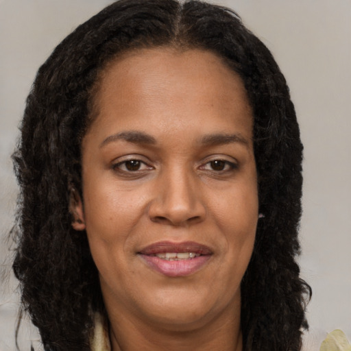 Joyful black young-adult female with long  brown hair and brown eyes