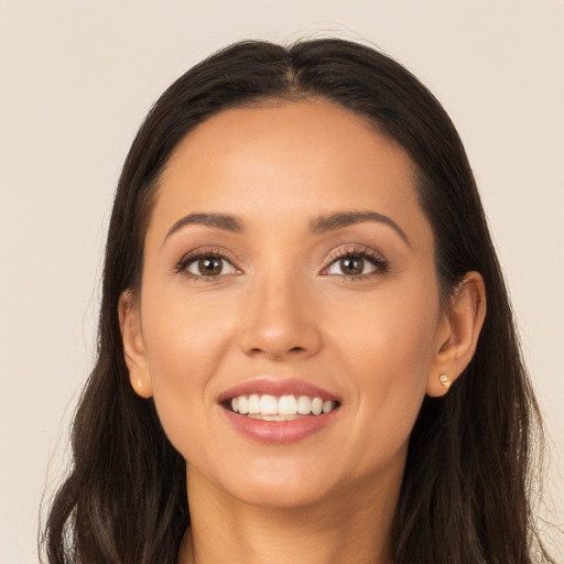 Joyful latino young-adult female with long  brown hair and brown eyes