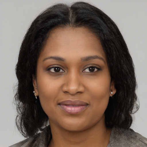 Joyful black young-adult female with medium  brown hair and brown eyes