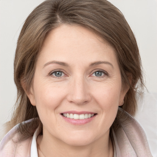 Joyful white young-adult female with medium  brown hair and grey eyes