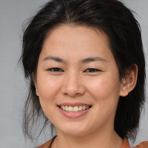 Joyful asian young-adult female with medium  brown hair and brown eyes