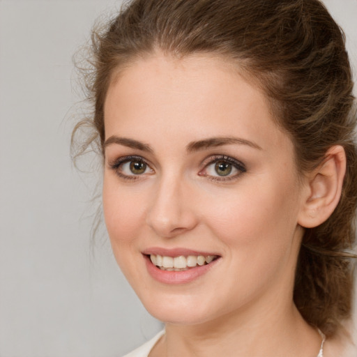 Joyful white young-adult female with medium  brown hair and green eyes