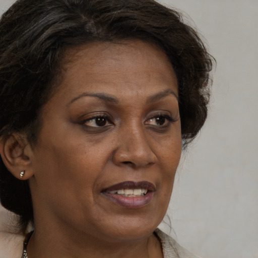 Joyful black adult female with medium  brown hair and brown eyes