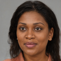 Joyful black young-adult female with long  brown hair and brown eyes