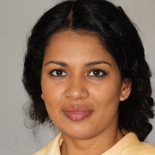 Joyful black young-adult female with medium  brown hair and brown eyes