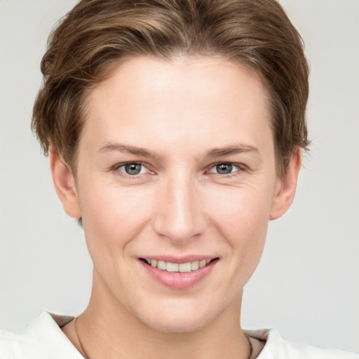 Joyful white young-adult female with short  brown hair and grey eyes